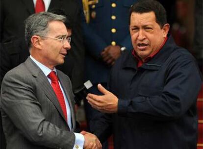 Uribe, de visita en la capital venezolana, saluda a Chávez durante el repaso de las tropas