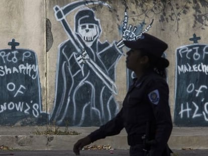 Una oficial de polic&iacute;a camina en un barrio controlado por pandilleros. 