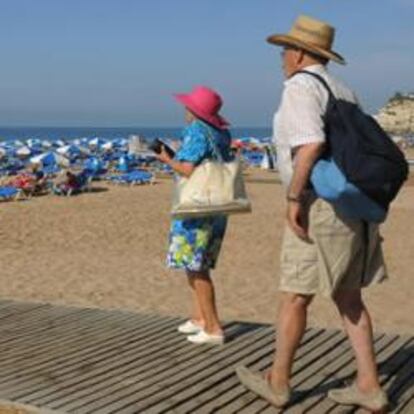 Dos turistas acuden a la playa de Benidorm (Alicante).