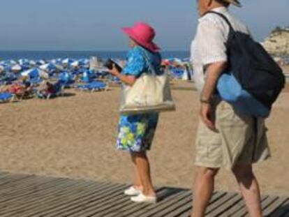 Dos turistas acuden a la playa de Benidorm (Alicante).