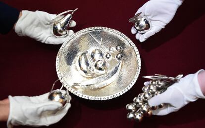 Miembros del personal del palacio de Buckingham muestran las piezas del cuenco de plata que el presidente de Zambia regaló a la reina