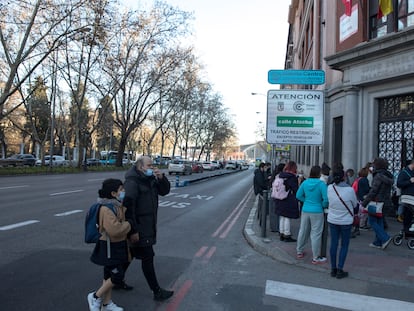 Los padres y madres de alumnos esperan la salida de los alumnos del colegio público Palacio Valdés, en el paseo del Prado de Madrid.