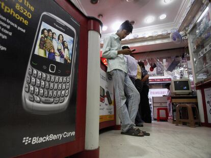 Un hombre consulta su móvil en una tienda de telefonía en la ciudad de Hyderabad, en India.