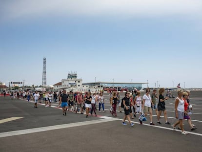 Un grupo de viajeros atraviesa la pista de aterrizaje del aeropuerto de Gibraltar.