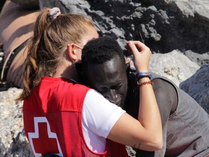 Una trabajadora de la Cruz Roja y un migrante que ha logrado cruzar uno de los espigones fronterizos de Ceuta este martes se abrazan. Ceuta ha vivido hoy una avalancha de migrantes sin precedentes en España al registrarse la entrada en poco más de 24 horas de unas 8.000 personas, muchas de ellas menores. EFE/Reduan