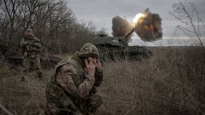 Un par de soldados ucranios se resguardan tras el dsparo de un tanque de guerra en Donetsk, Ucrania, el pasado 28 de diciembre.