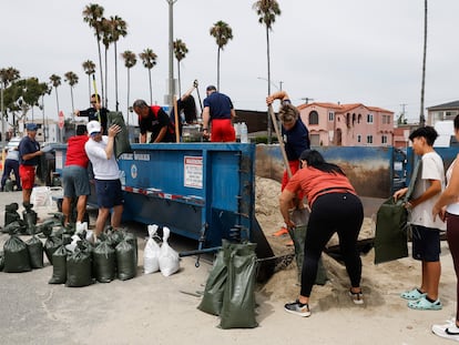 Residentes de Long Beach llenan sacos con arena para prepararse ante posibles inundaciones causadas por la tormenta.