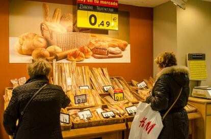 Dos mujeres, en la sección de panadería de un supermercado.