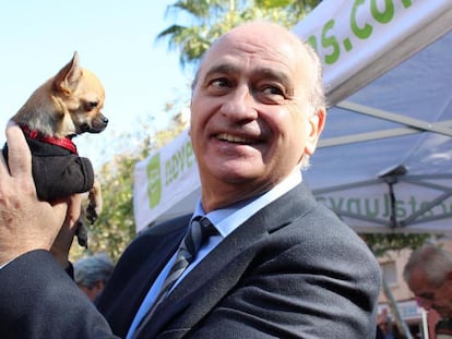 Jorge Fernández Díaz, exministro del Interior, bromea con una perrita en una campaña electoral, en 2011.