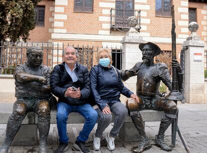 Los chilenos José Miguel González y Daisy Clift, de visita en Madrid, han tomado el Cercanías para visitar Alcalá de Henares. Posan sentados junto a las esculturas del Quijote y Sancho Panza, delante de la Casa Natal de Cervantes.