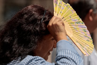 Una mujer se protege del calor con un abanico este martes en Valencia, bajo aviso amarillo por altas temperaturas.