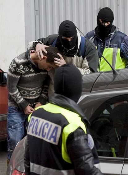 Agentes de la policía introducen en un coche, esposado, a Asier Ortiz de Guinea, ayer en Vitoria.