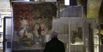 Un visitante observa una de las piezas del tesoro de Sijena instaladas ya en una de las salas del monasterio.