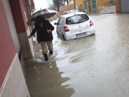 Un hombre camina por una calle anegada en Algeciras.