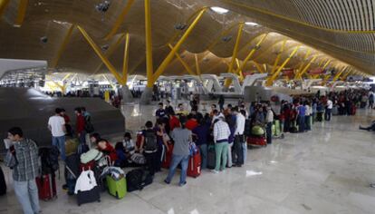Cientos de pasajeros afectados por las cancelaciones aéreas forman cola frente a los mostradores de Iberia en la terminal 4 del aeropuerto de Barajas.