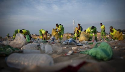 Operaris municipals netegen les platges de Barcelona.