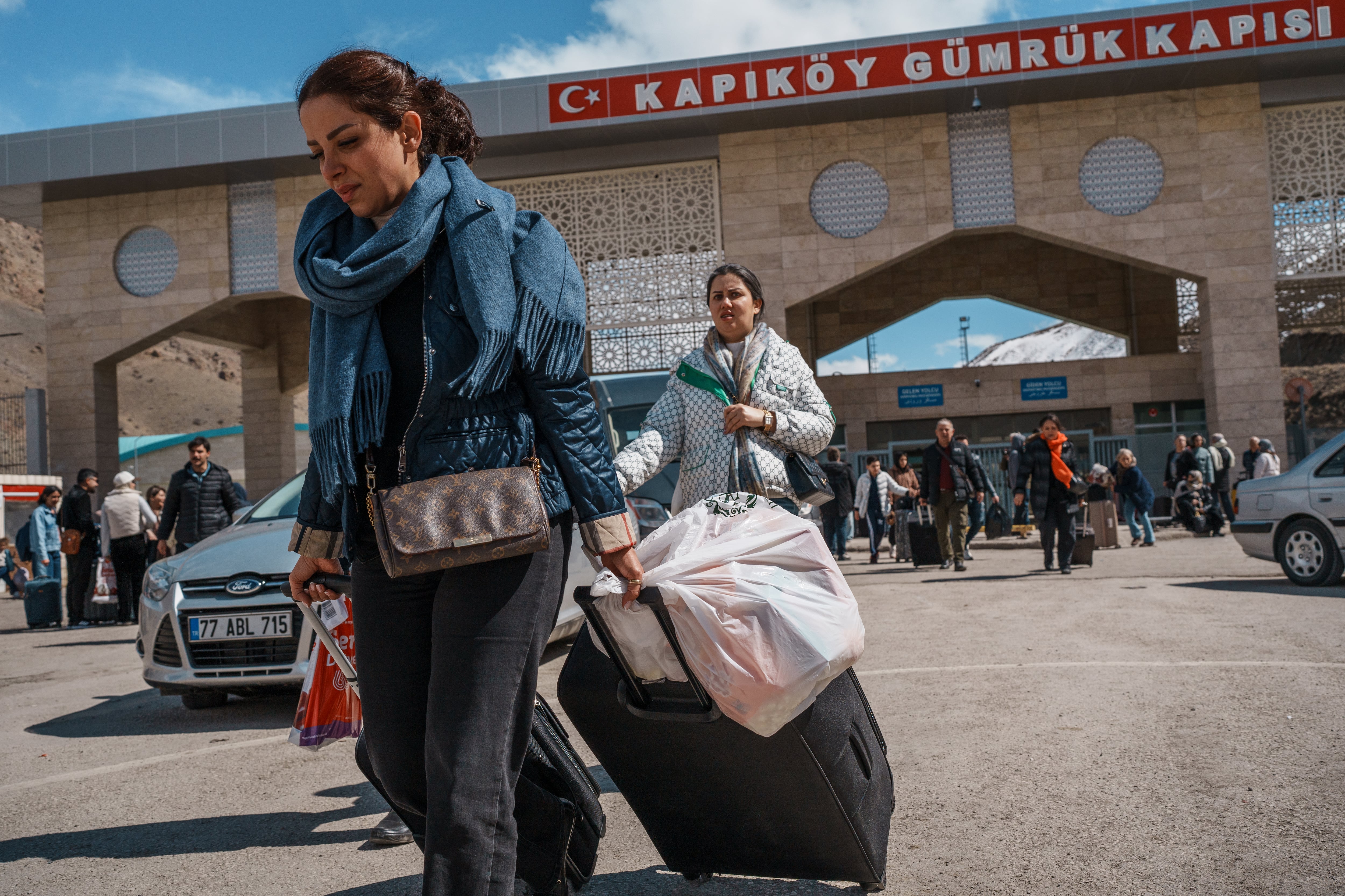 Viajeros iraníes llevan su equipaje al entrar por la puerta aduanera de Kapiköy, en la frontera entre Turquía e Irán, en la provincia de Van, el 20 de marzo.