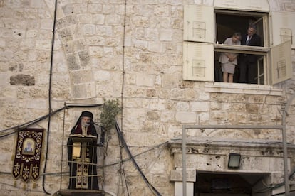 Una pareja observa a un sacerdote griego ortodoxo durante la ceremonia del lavado de pies fuera de la iglesia de la Santa Sepultura en la ciudad vieja de Jerusalén, el 28 de abril de 2016.