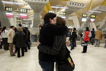 Dos figurantes ensayan la despedida junto a los mostradores de facturación de la nueva terminal del aeropuerto de Barajas.