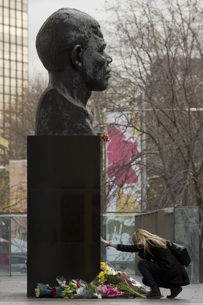 Una mujer toca el pedestal de una estatua del expresidente sudafricano Nelson Mandela, al lado del Royal Festival Hall, en la orilla sur de Londres.