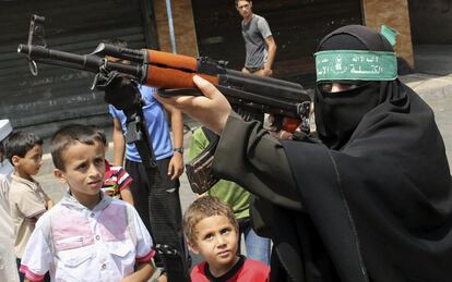 Una mujer apunta con un rifle Kaláshnikov durante una protesta de Hamás contra nuevos ataques israelíes sobre Cisjordania y Jerusalén tras la oración del viernes en el campo de refugiados de Jabaliya, al norte de la Franja de Gaza.