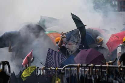 Manifestantes envueltos en gases lacrimógenos y paraguas en los enfrentamientos con la policía este miércoles en Hong Kong. El Ejecutivo que preside la ministra jefe Carrie Lam ha replicado a los manifestantes que ya ha modificado el proyecto de ley en dos ocasiones y que, para extraditar a los sospechosos que reclame China, exigirá garantías a ese país; la solicitud no podrá tener motivaciones políticas ni religiosas, e incluso si los tribunales autorizan la entrega, el Gobierno autónomo tendrá la última palabra.