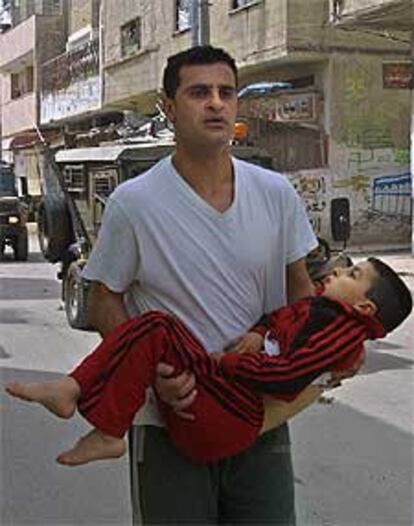 Un familiar lleva al niño Jaled Walawil en brazos momentos después del tiroteo que le ha costado la vida.