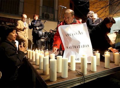 Varios ciudadanos encienden velas en el homenaje a las mujeres fallecidas por violencia doméstica que se organizó anoche en Zaragoza.