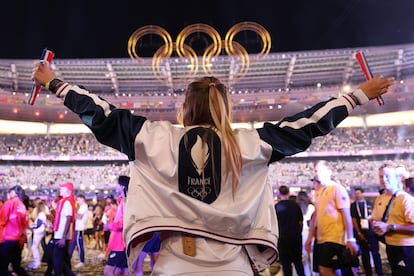 Una atleta del equipo de Francia levanta los brazos durante la ceremonia de clausura .