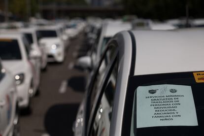 Un cartel en un taxi anuncia servicios mínimos gratuitos de traslados para personas con movilidad reducida, ancianos y familias con niños, en Madrid.