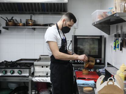 Juan Beltrán, cocinero y socio de FoodCraft, empaqueta un pedido en la cocina de un local reformado de Tetuán