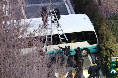 Oficiales de policía usan una escalera para subir a un autobús estacionado a la entrada de la residencia oficial del presidente surcoreano cesado para ejecutar la orden de arresto, este miércoles en Corea del Sur.