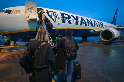 Un grupo de pasajeros sube, con equipaje de mano, a un avión de Ryanair en el aeropuerto de Dublín (Irlanda).