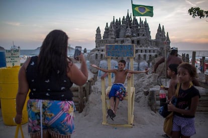 Bañistas se sacan fotos delante del castillo de Marcio Mizael Matolas.