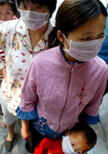 Trabajadores chinos hacen cola en un hospital de Pekín para un chequeo.