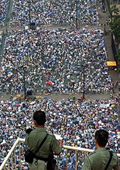 Dos policías miran a los manifestantes en el parque Victoria de Hong Kong.