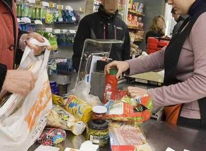 Una cajera atiende a los clientes de un supermercado.