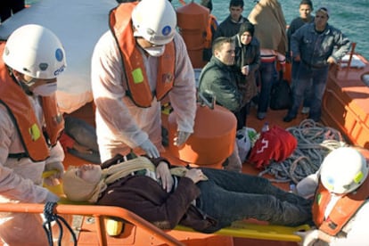 Miembros de Salvamento Marítimo desembarcan en Almería a una mujer que viajaba en la patera siniestrada.