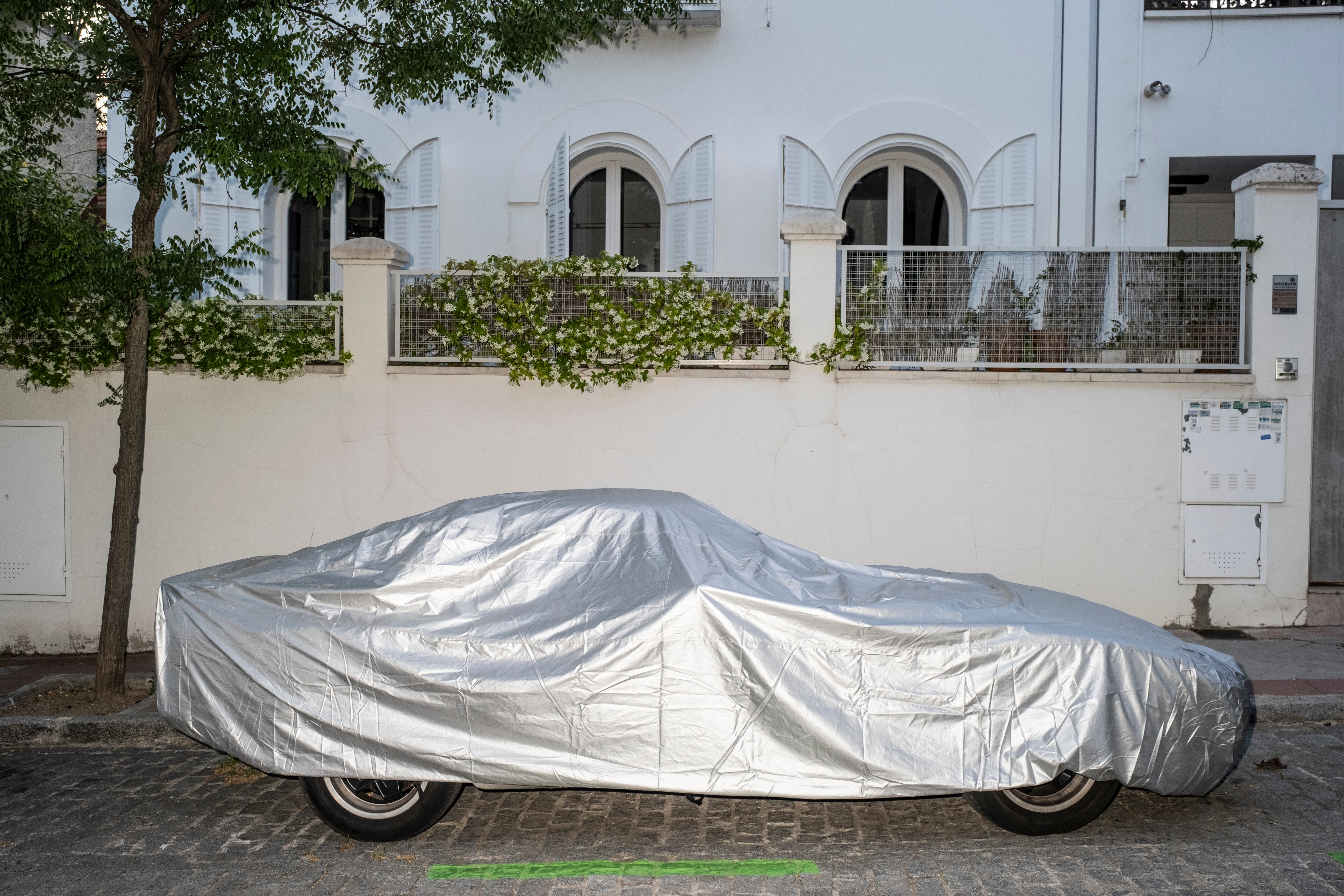 Un coche cubierto por una lona en la colonia Albéniz.