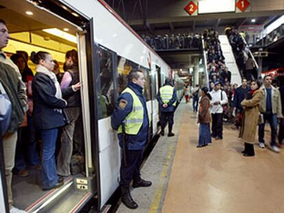 Los guardias de seguridad de la estación de Atocha controlaban ayer, como es habitual, la subida y bajada de pasajeros de los trenes de cercanías. La afluencia de viajeros era mucho menor de lo normal. 

/ LUIS MAGÁN