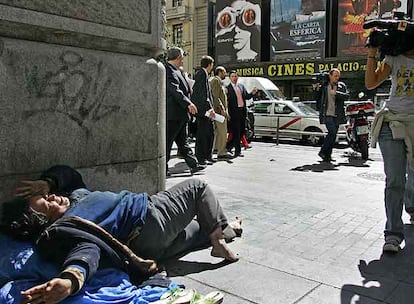 Una mendiga trata de ocultarse al paso de los miembros de la Comisión de Garantías por la Gran Vía.