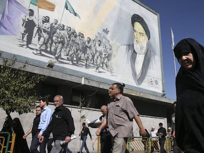 Iran&iacute;es pasan frente a una pintura del ayatol&aacute; Jomeini en Teher&aacute;n, Ir&aacute;n.