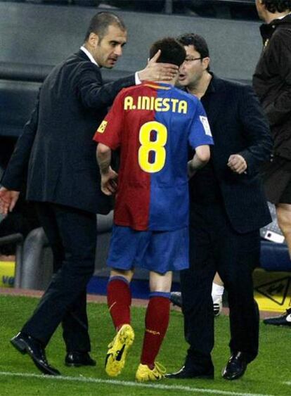 Guardiola y el médico del Barça consuelan a Iniesta.