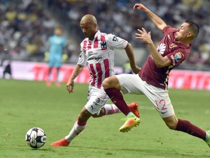 El uruguayo Carlos S&aacute;nchez (i) persigue el bal&oacute;n ante la presi&oacute;n del paraguayo Aguilar