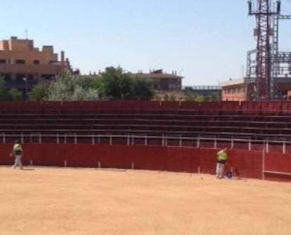 Los trabajadores de la limpieza terminando de pintar de rojo de nuevo la parte de la plaza afectada