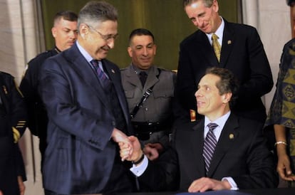 Sheldon Silver, de pie, estrecha la mano del Gobernador de Nueva York, Andrew Cuomo, en un acto de 2013.