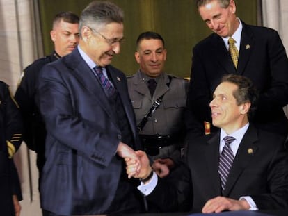 Sheldon Silver, de pie, estrecha la mano del Gobernador de Nueva York, Andrew Cuomo, en un acto de 2013.