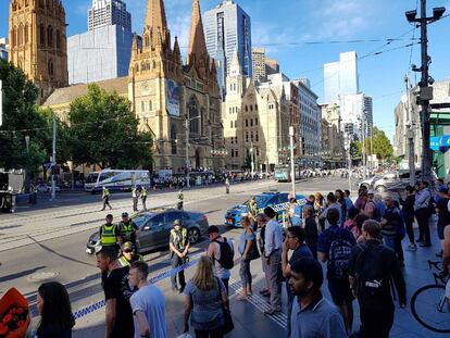 Ciudadanos se acercan a la zona del atropello, acordonada por la policía y los servicios de emergencias en Melbourne.