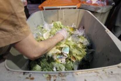 Un voluntario recoge alimentos de un contenedor de basura. EFE/Archivo