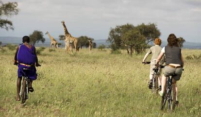 Un masai guía a una familia en una excursión en bici por en el parque nacional de Chyulu Hills (Kenia).